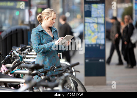 junge Frau mit Apple iPad auf Street in London für Internetzugang Stockfoto