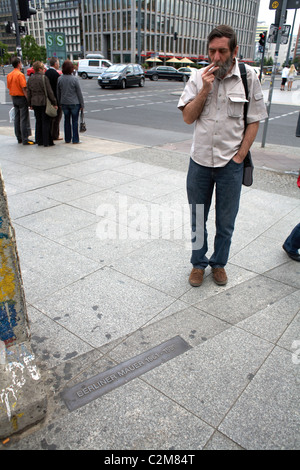 Ein Mann blickt auf eine Tafel zum Gedenken an den ehemaligen Standort der Berliner Mauer, Berlin, Deutschland Stockfoto