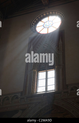 Lichtstrahlen platzen durch eine kreisförmige Buntglasfenster. . Stockfoto