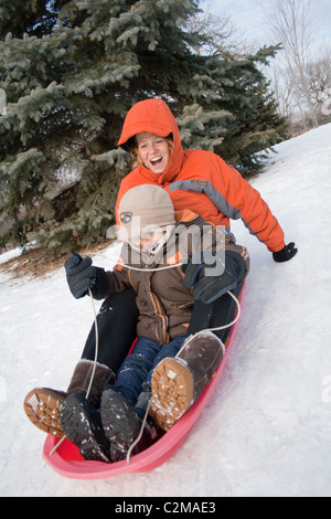 Mutter und Sohn Alter 6 und 40 schneereichen Winter Merriam Park Hügel hinunter rodeln. St Paul Minnesota MN USA Stockfoto