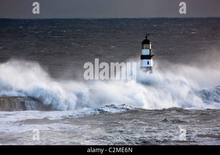 Seaham, Teesside, England; Wellen, die auf Leuchtturm Stockfoto