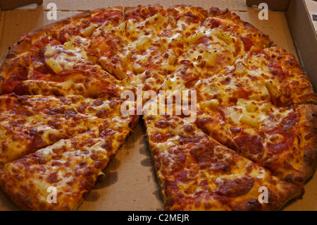 Salami, Schinken und Ananas Pizza in box Stockfoto