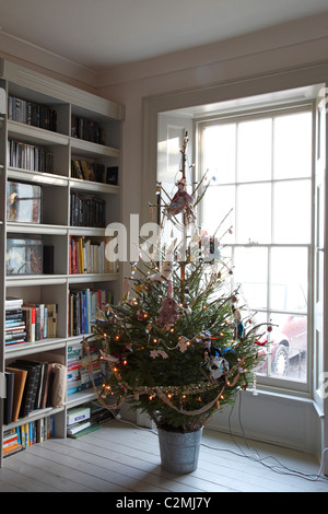 Weihnachtsbaum mit Jessica Quinn Puppen im Wohnzimmer mit Bücherregal Stockfoto