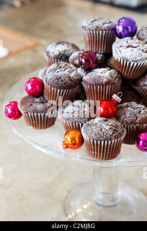 Muffins mit Weihnachtskugeln auf Kuchen stehen Stockfoto