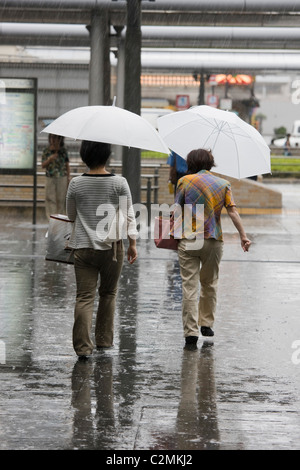 Fußgänger zu Fuß bei starkem Regen draußen Bahnhof Kyoto in Kyoto, Japan Stockfoto