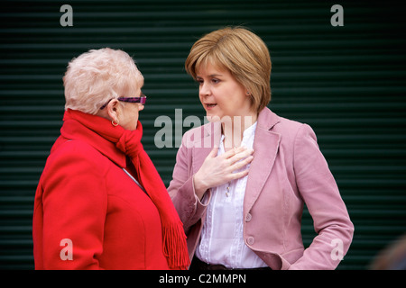 Nicola Sturgeon (rechts), Scottish National Party (SNP) stellvertretender Vorsitzender, im Gespräch mit einer Frau bei der Werbetätigkeit in Govan. Stockfoto