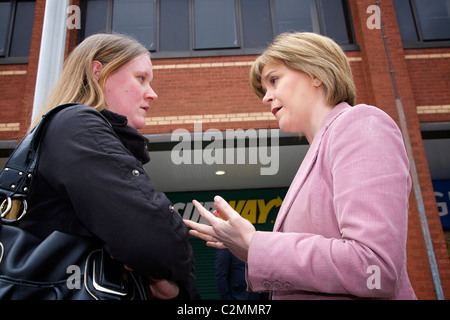 Nicola Sturgeon (rechts), Scottish National Party (SNP) stellvertretender Vorsitzender, im Gespräch mit einheimischen einer Frau bei der Werbetätigkeit in Govan. Stockfoto