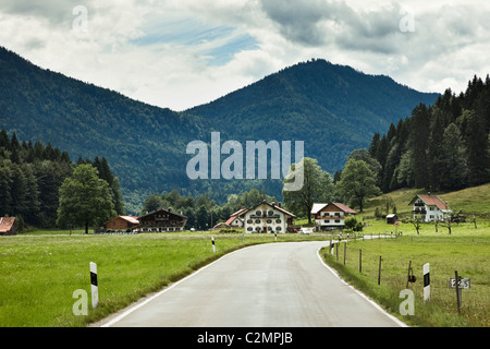 Straße durch ein kleines Dorf in Bad Tölz-Wolfratshausen, Bayern, Deutschland, Europa Stockfoto