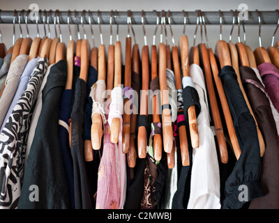 Kleiderstange im Schrank, Herren- und Damen Kleidung auf Holzbügel Stockfoto