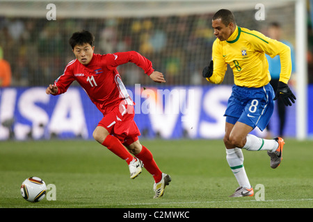 In Guk Mun von Nordkorea (11) steuert den Ball gegen Gilberto Silva aus Brasilien (8) während eines Spiels 2010 FIFA World Cup Gruppe G Stockfoto