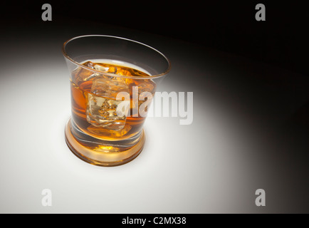 Glas Whisky oder andere alkoholische Getränk und Eis unter Spot-Licht. Stockfoto