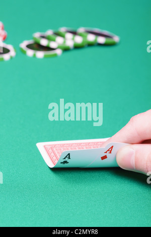 Poker-Spieler mit zwei Asse und Chips am grünen Tisch Stockfoto