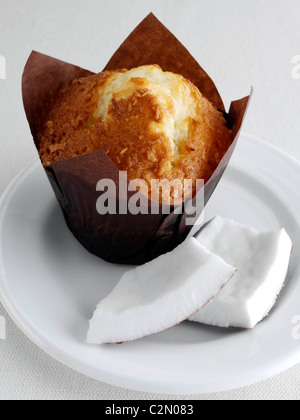 Kokos-Muffins mit Stücken der Kokosnuss auf einem weißen Teller Stockfoto