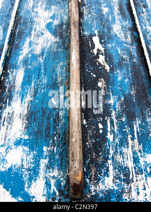 Der zerkratzten blauen Rumpf eines kleinen alten Fischerbootes einladendsten, Dorset, UK. Stockfoto