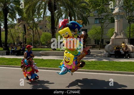 Mann, Verkauf von bunten Luftballons mit lustigen Gesichtern auf Straße in Barcelona Stockfoto