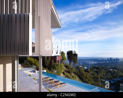 Modernes Einfamilienhaus, West Hollywood, Kalifornien. Blick auf Terrasse, Infinity Pool Tand Bäume in Los Angeles Becken. Stockfoto