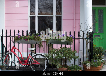 Ein Fahrrad geparkt vor einem farbigen Terrassenhäuser Chalcot Square, in der Nähe von Primrose Hill, London, NW1, England Stockfoto