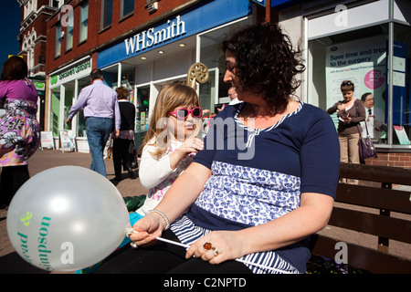 Großbritannien, England, Staffordshire, Lauch, Derby Street, Mutter und Tochter saß auf der Bank im Sonnenschein Stockfoto