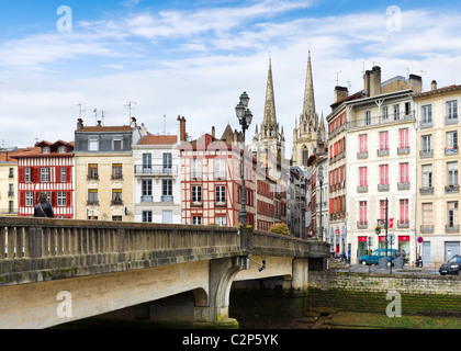 Traditionelle Häuser entlang der Ufer des Flusses Nive Grand Bayonne mit dem Dom hinter Bayonne (Baiona), Cote Basque, Frankreich Stockfoto