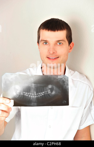 Porträt des kaukasischen Mann Arzt tragen einheitliche stehende Wand im Krankenhaus Blick in die Kamera Lächeln Stockfoto