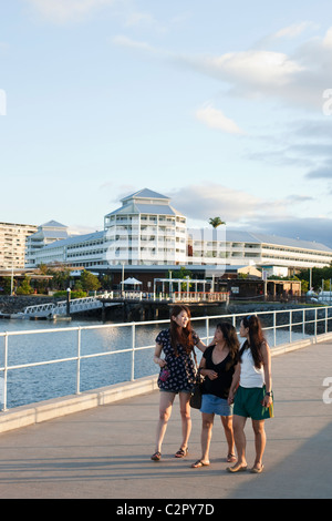 Touristen zu Fuß entlang Marlin Marina Steg mit Shangri-La Hotel im Hintergrund. Cairns, Queensland, Australien Stockfoto