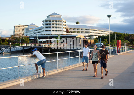 Touristen zu Fuß entlang Marlin Marina Steg mit Shangri-La Hotel im Hintergrund. Cairns, Queensland, Australien Stockfoto