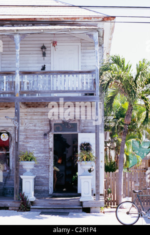 Zwei Etagen Schindeln Haus, weiß lackiert, mit Balkon und Veranda, Wetter geschlagen, abblätternde Farbe, Urnen mit Farnen Stockfoto