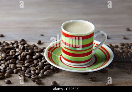 Kaffee in gestreiften Schale mit Bohnen Stockfoto