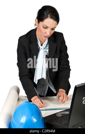 Ingenieur-Frau arbeiten in ihrem Büro auf Laptop und Projekte und Pläne mit Bleistift Stockfoto