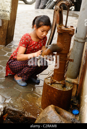 junges Mädchen sammeln von Wasser aus kommunalen Wasser-Pumpe, Kathmandu Straße leben, Kathmandu, nepal Stockfoto