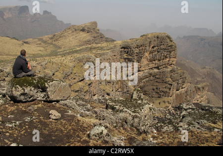 Simien Mountains, Nord-Äthiopien: Ein Trekker nimmt in der Ansicht von der Böschung Krempe oben Chenek Camp. Stockfoto