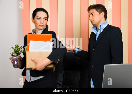 Business-Frau ist von ihrem Chef entlassen und aufgefordert, das Büro verlassen mit ihren Werten in einem Karton Stockfoto