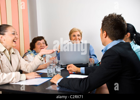 Geschäftsleute, die mit lustigen Gespräch zu treffen und sie Lächeln und lachen zusammen Stockfoto