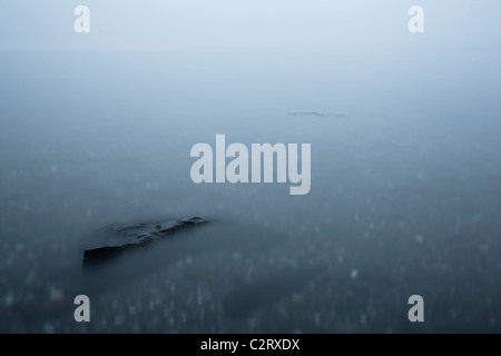 Ein Stein wird unter Wasser im Meer fallenden Abend Nebel gesehen. Stockfoto