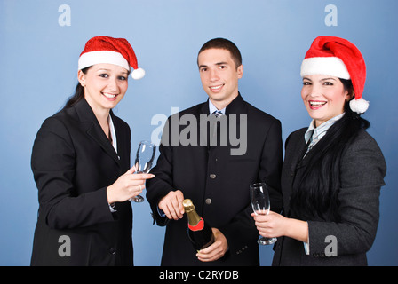 Geschäftsleute, Weihnachten mit Champagner zu feiern und Spaß haben, Santa Hüte tragen, gemeinsam lachen Stockfoto