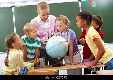 Porträt von Schülern Blick auf Globus beim hören Lehrer im Erdkundeunterricht Stockfoto