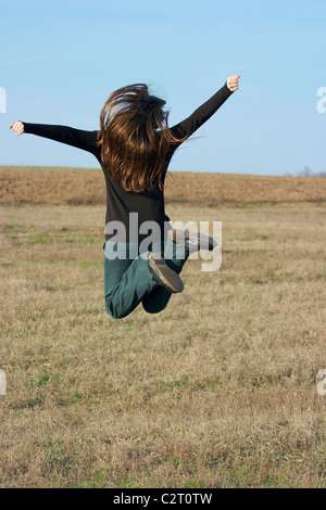 Glückliches Mädchen auf einer trockenen Wiese herumspringen Stockfoto