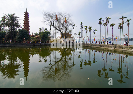 Horizontale Ansicht von einem der von Bäumen gesäumten Damm führt zu Tran Quoc Pagode auf dem Westsee in Hanoi Stockfoto