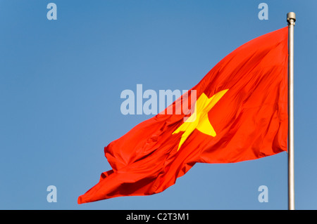 Vertikale Nahaufnahme von "Cờ đỏ Sao Vàng" (rote Flagge mit einem gelben Stern) Staatsflagge Vietnam seit 1945 vor einem blauen Himmel. Stockfoto