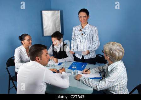 Business-Frau eine Rede und eine Papier bei Treffen mit ihren Kollegen halten Stockfoto