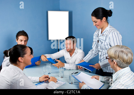 Treffen mit fünf fröhlichen Geschäft Menschen, eine Geschäftsfrau, die geben alle Papierarbeiten und sie lachen zusammen, leere Diagramm Stockfoto