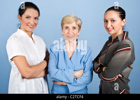 Drei Business-Frauen stehen in einer Linie mit verschränkten Armen und lächelnd, senior Geschäftsfrau in der Mitte des jüngeren Kollegen Stockfoto