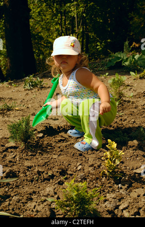 die kleine Gärtnerin mit Kinder-Schaufel. Natur Stockfoto