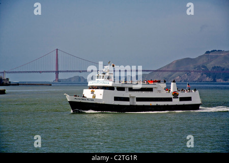 Ein Touristenboot Kreuzfahrt zu Pässen San Francisco Oakland Bay Bridge auf dem Weg zur Insel Alcatraz und seinem berüchtigten Gefängnis. Stockfoto