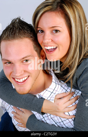Junger Mann geben seine hübsche blonde Freundin A Huckepack-Fahrt Stockfoto