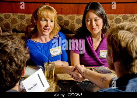 Speed dating Teilnehmer Kontakte knüpfen in der Bar des California Restaurant. Im Speed-dating, sind Männer und Frauen gedreht, um zu treffen Stockfoto