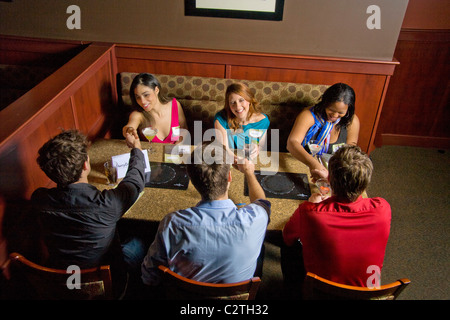 Speed dating Teilnehmer Kontakte knüpfen in der Bar des California Restaurant. Im Speed-dating, sind Männer und Frauen gedreht, um zu treffen Stockfoto