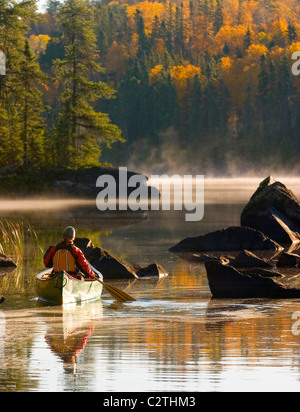 Frau Paddel Kanu auf einem See in den frühen Morgenstunden im Herbst Boundary Waters in Superior National Forest Minnesota Stockfoto
