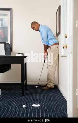 Afrikanische amerikanische Geschäftsmann setzen Golfball Stockfoto