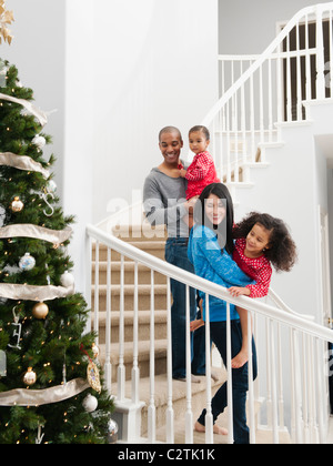 Familie absteigend Treppe am Weihnachtsmorgen Stockfoto